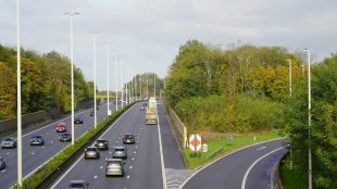 A highway with a bunch of cars driving down it