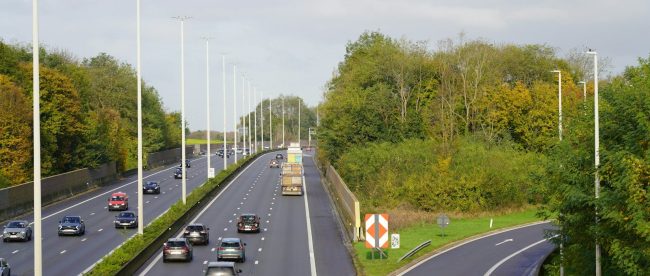A highway with a bunch of cars driving down it